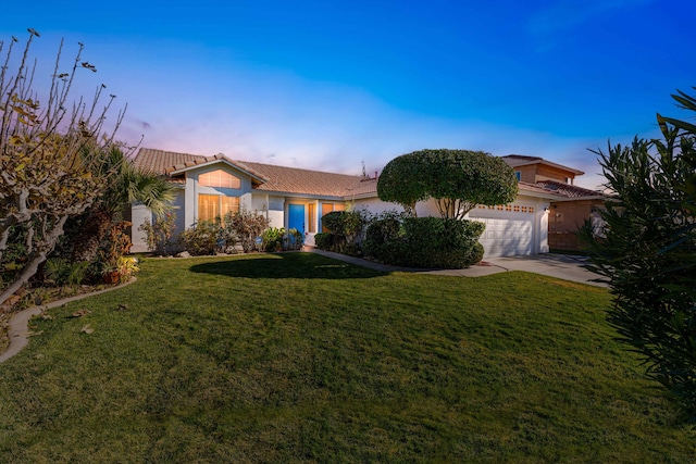 view of front of house with a garage and a lawn