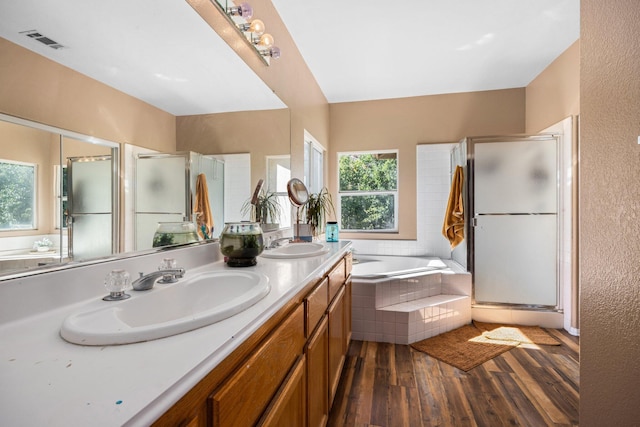 bathroom with hardwood / wood-style floors, vanity, and independent shower and bath