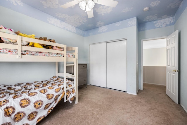 carpeted bedroom with ceiling fan and a closet