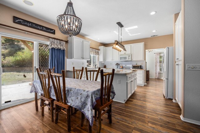 dining space with dark hardwood / wood-style flooring and a notable chandelier