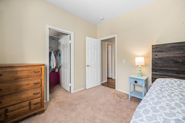 bedroom featuring a spacious closet, light carpet, and a closet