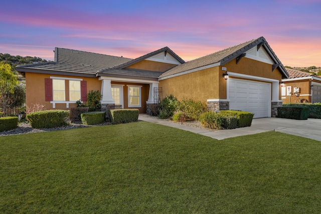 view of front of house featuring a garage and a yard