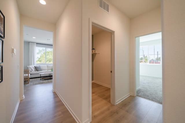 hall with visible vents, recessed lighting, baseboards, and wood finished floors