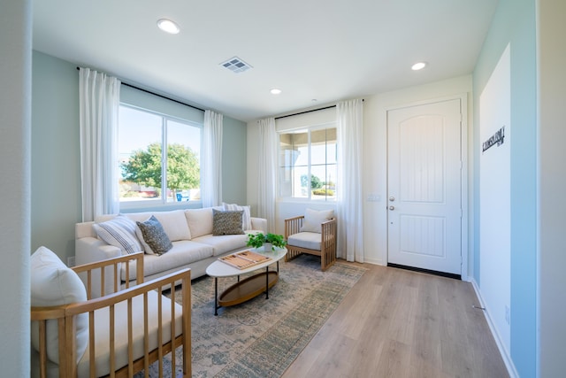 living room featuring recessed lighting, baseboards, visible vents, and light wood-type flooring