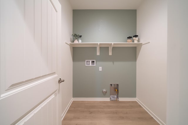 clothes washing area featuring laundry area, baseboards, hookup for a washing machine, light wood-type flooring, and hookup for a gas dryer