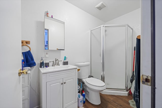 bathroom with visible vents, toilet, a stall shower, vanity, and wood finished floors