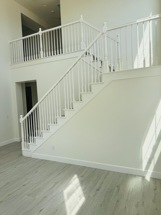 44838 Lotus Ct, Lancaster, CA 93536 - staircase featuring baseboards, wood finished floors, and a towering ceiling