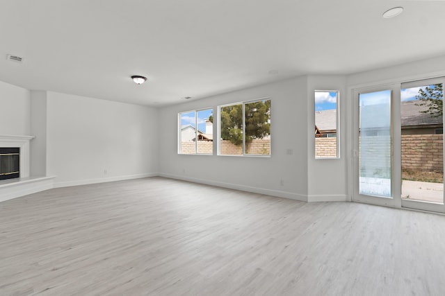 44838 Lotus Ct, Lancaster, CA 93536 - unfurnished living room featuring wood finished floors, visible vents, a healthy amount of sunlight, and baseboards