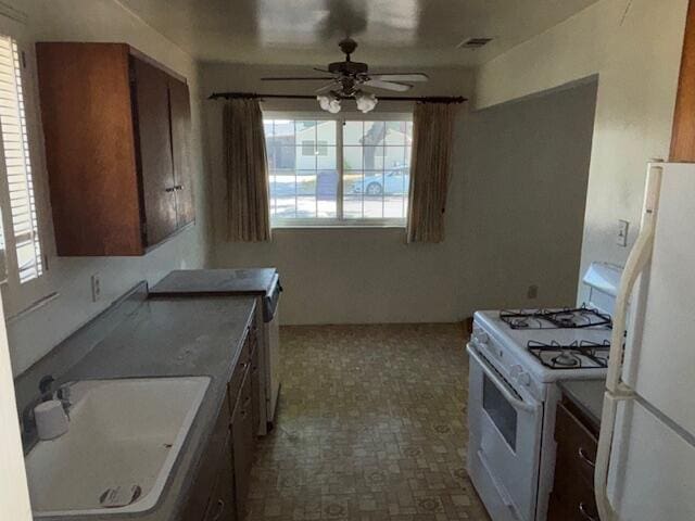 19 E 21st St, Tracy, CA 95376 - kitchen with white appliances, a sink, ceiling fan, and plenty of natural light