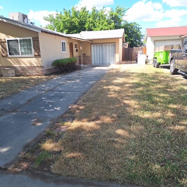 19 E 21st St, Tracy, CA 95376 - view of front of property featuring stucco siding, an attached garage, and concrete driveway
