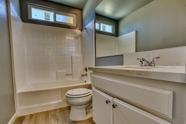 1236 Marion Ave, Lancaster, CA 93535 - full bathroom with wood finished floors, toilet,  shower combination, vanity, and a textured wall