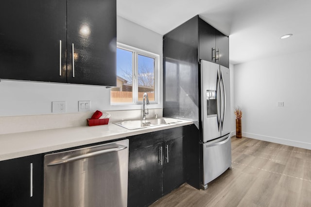 kitchen featuring dark cabinets, a sink, light countertops, appliances with stainless steel finishes, and modern cabinets