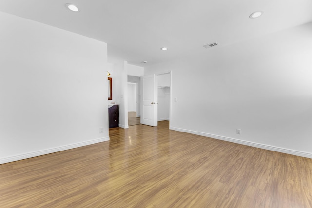 unfurnished room featuring light wood-type flooring, baseboards, visible vents, and recessed lighting