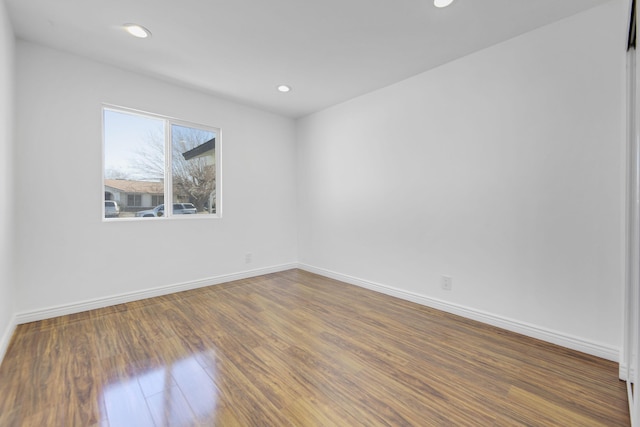 spare room featuring baseboards, dark wood finished floors, and recessed lighting