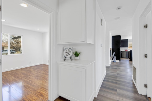 hallway with recessed lighting, dark wood finished floors, and baseboards