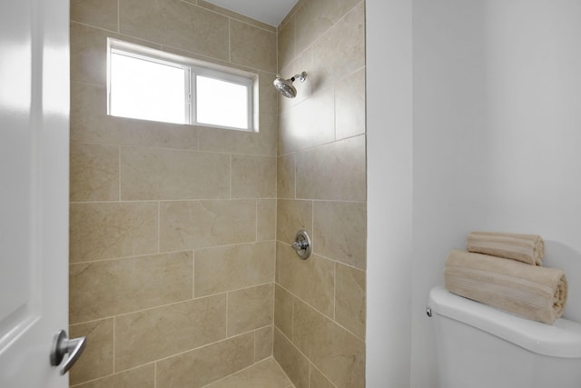 bathroom featuring toilet and a tile shower