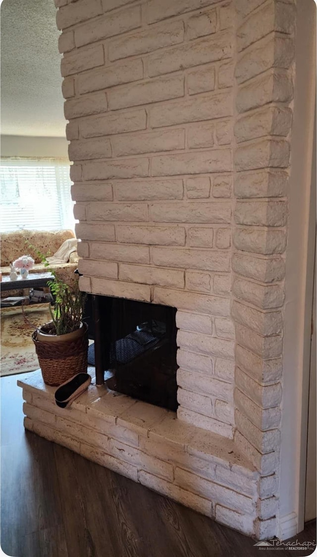 room details featuring a brick fireplace and wood finished floors