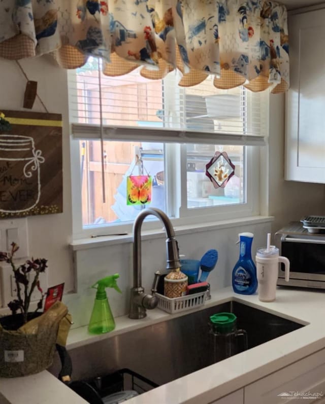 interior details featuring light countertops and a sink