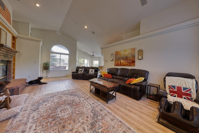 living area with wood finished floors, ceiling fan, a fireplace, high vaulted ceiling, and recessed lighting