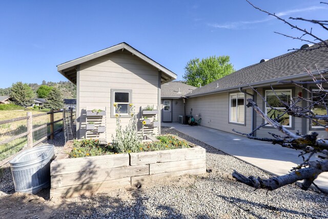 back of house featuring fence, central AC, and a patio area