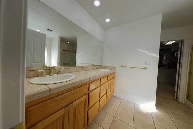full bathroom featuring a stall shower, double vanity, tile patterned flooring, a spacious closet, and recessed lighting