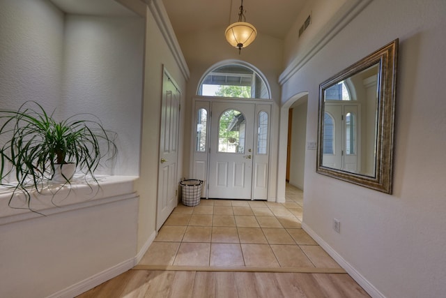 foyer with plenty of natural light, baseboards, and light tile patterned flooring