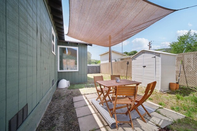 18133 Ellstree Dr, Lake Hughes, CA 93532 - view of patio / terrace featuring outdoor dining space, a fenced backyard, a shed, and an outbuilding