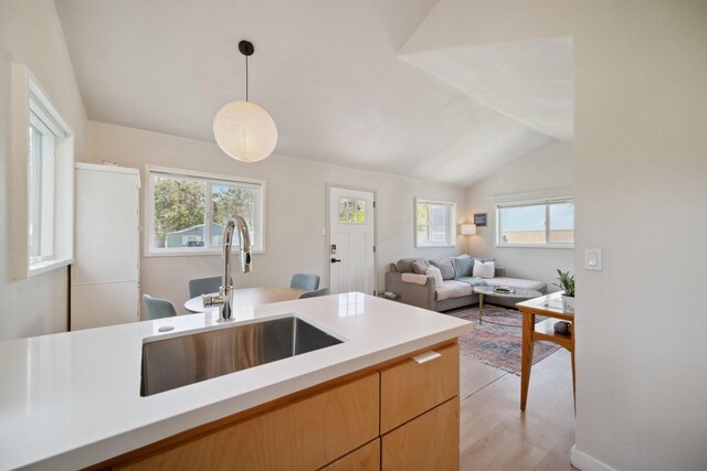 18133 Ellstree Dr, Lake Hughes, CA 93532 - kitchen with a sink, lofted ceiling, light countertops, decorative light fixtures, and light wood-style floors