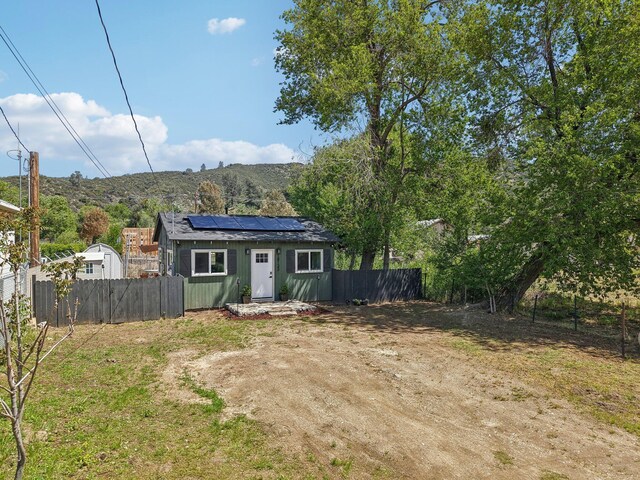 18133 Ellstree Dr, Lake Hughes, CA 93532 - view of front of home with roof mounted solar panels, fence, driveway, and a mountain view
