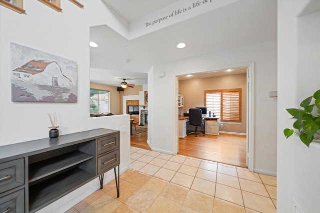 hall with a healthy amount of sunlight and light tile patterned floors