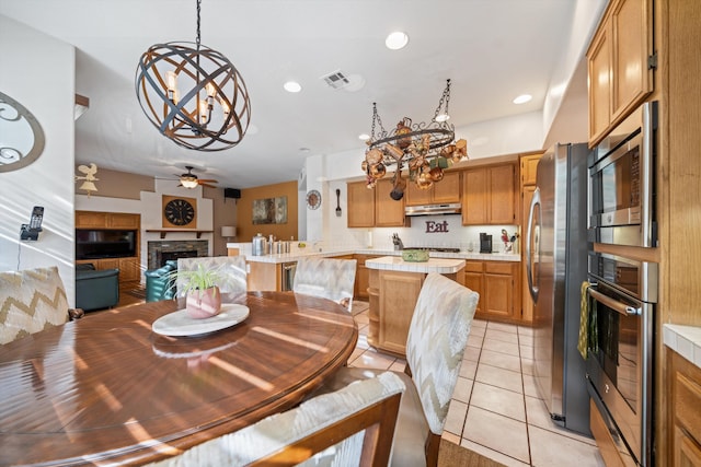 dining room with light tile patterned flooring and ceiling fan with notable chandelier