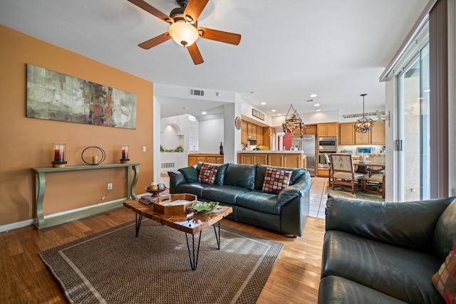 living room with ceiling fan and light hardwood / wood-style flooring