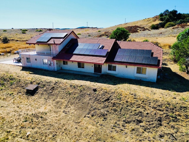 rear view of property with solar panels