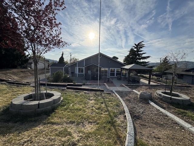 rear view of house featuring a lawn, a patio, and a gazebo