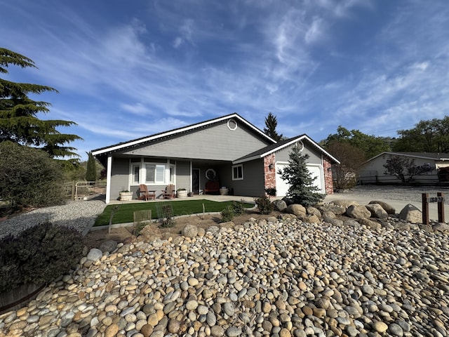 view of front facade featuring fence, a front yard, brick siding, an attached garage, and driveway
