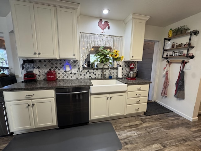 kitchen with dark countertops, dishwashing machine, dark wood-type flooring, a sink, and backsplash