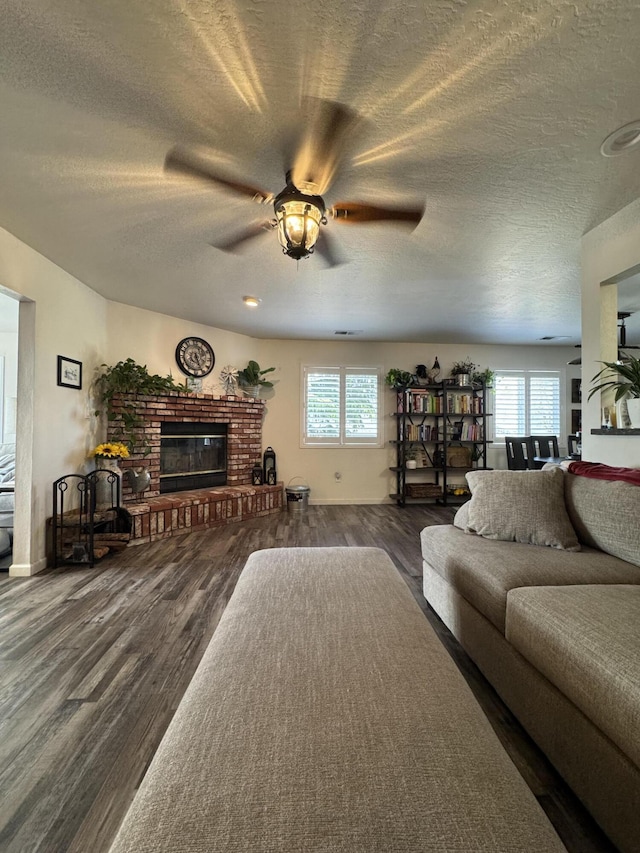 living area with dark wood-style flooring, a ceiling fan, a textured ceiling, and a healthy amount of sunlight