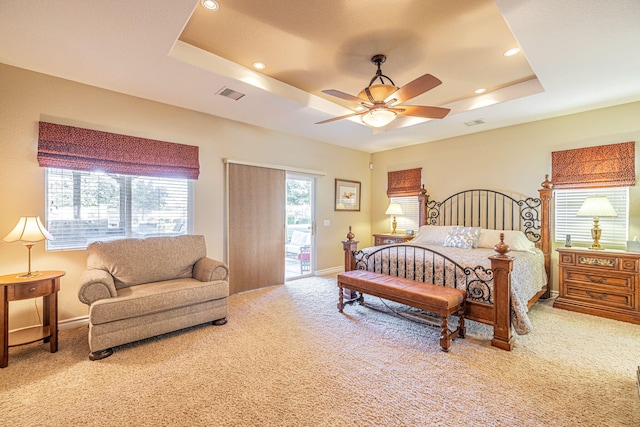 bedroom featuring a tray ceiling, ceiling fan, carpet, and access to outside