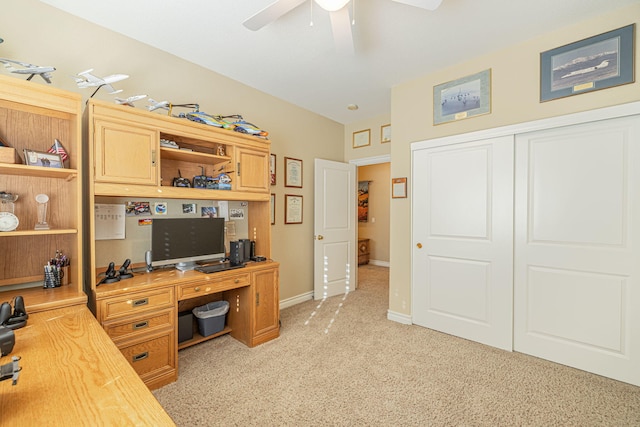 carpeted office space featuring ceiling fan