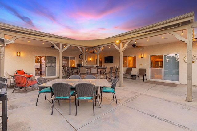 patio terrace at dusk featuring ceiling fan