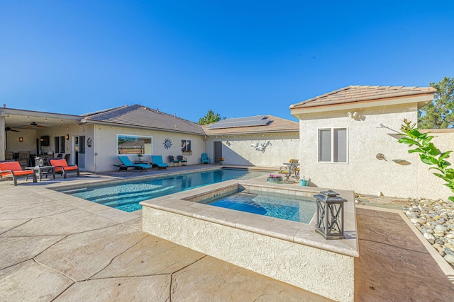 view of swimming pool with ceiling fan, an in ground hot tub, and a patio