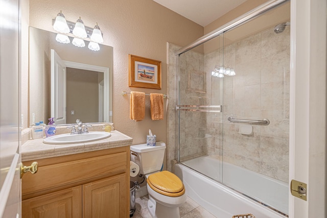 full bathroom featuring tile patterned floors, vanity, bath / shower combo with glass door, and toilet