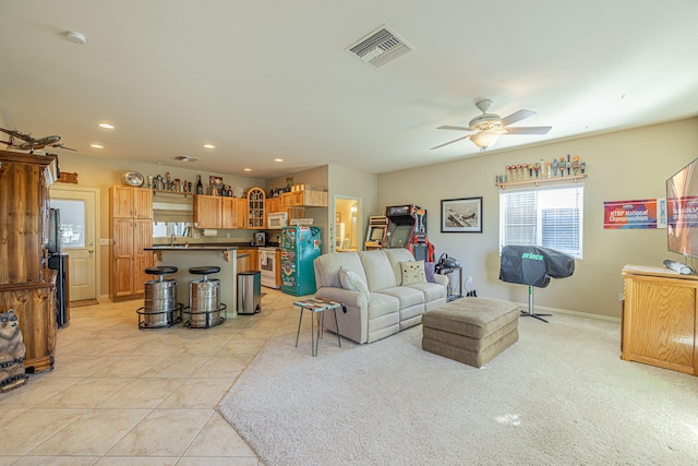 living room featuring ceiling fan, light tile patterned floors, and sink