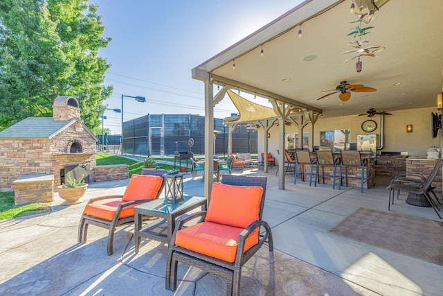 view of patio / terrace featuring an outdoor living space with a fireplace and an outdoor bar