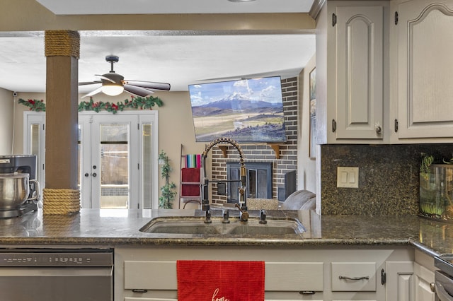 kitchen featuring stainless steel dishwasher, decorative backsplash, ceiling fan, and sink