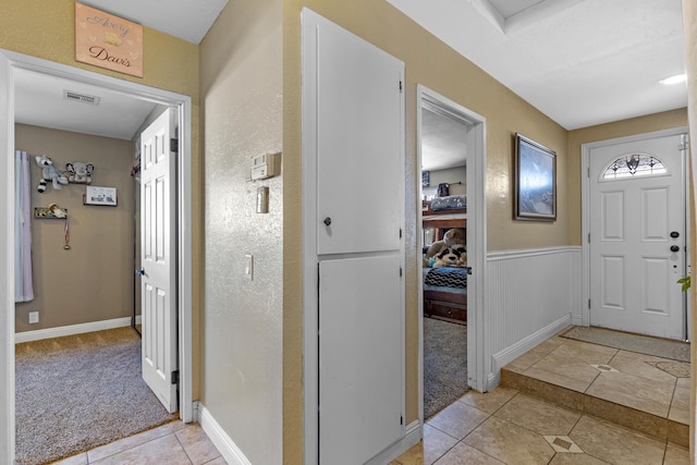 foyer entrance featuring light colored carpet