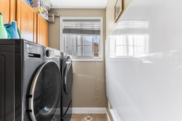 washroom featuring washing machine and dryer and cabinets