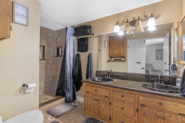 bathroom with tile patterned floors, vanity, curtained shower, and toilet