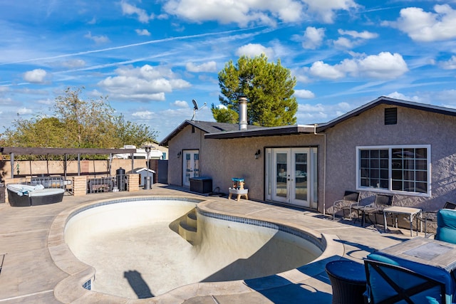 exterior space featuring a pool with hot tub and french doors