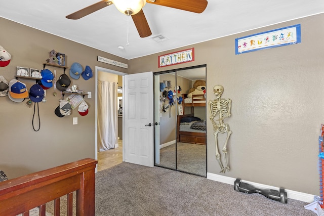 bedroom with a closet, ceiling fan, and light colored carpet